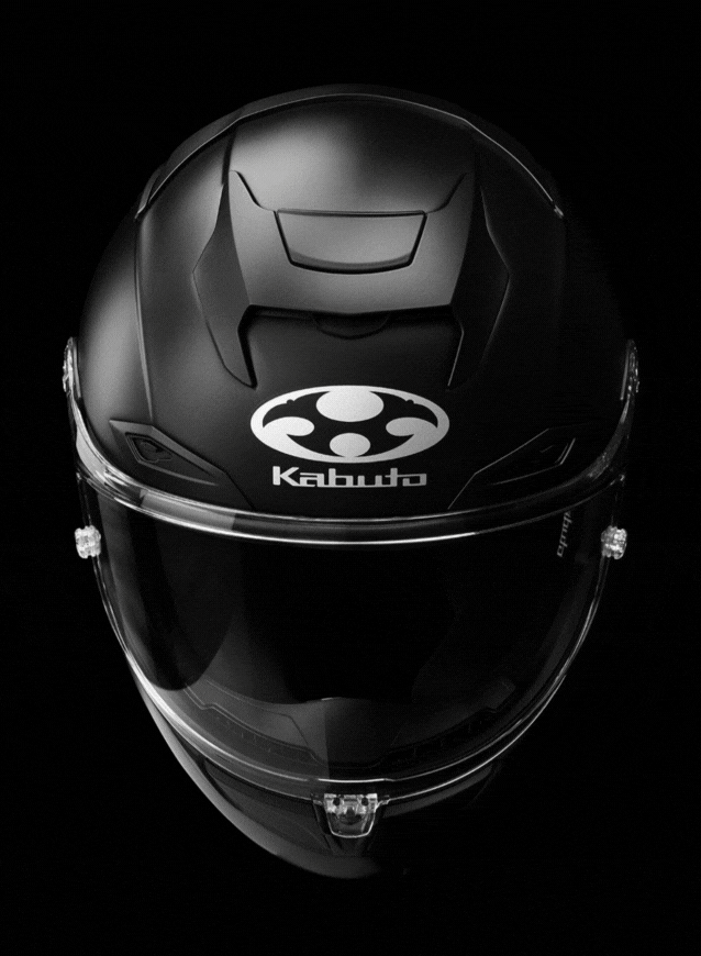 A high-resolution product photograph of a full-face motorcycle helmet styled as a traditional Japanese samurai kabuto switching between that and a normal kabuto f-17 black helmet, centered against a solid black studio backdrop. The helmet is shot straight-on at eye level with shallow depth of field, keeping the subject razor-sharp while the background falls into complete darkness