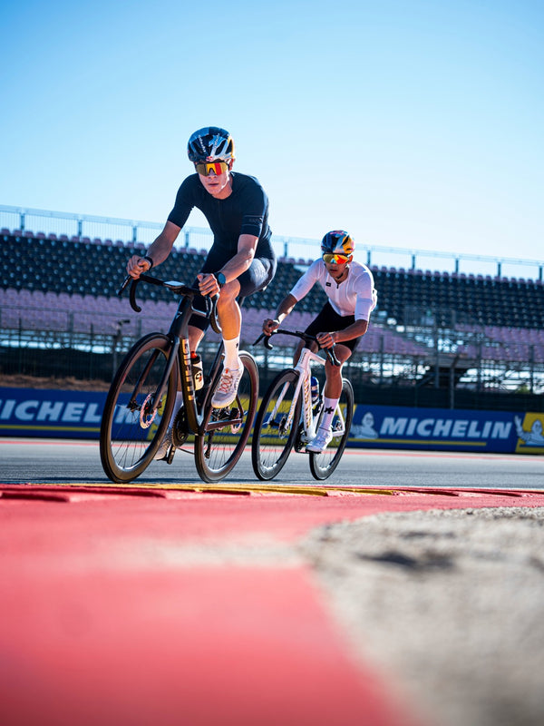 Two cyclists riding on a racetrack