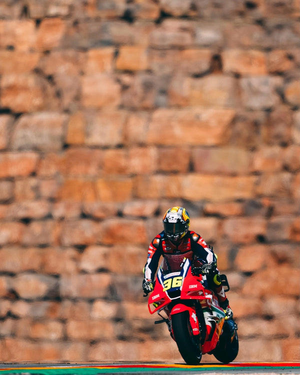 Joan Mir's No. 36 Honda riding past a stone wall