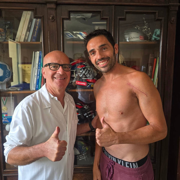 Two men giving a thumbs up in front of a bookcase