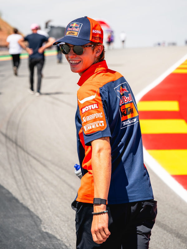Rider in Red Bull KTM team kit smiling in the pit lane
