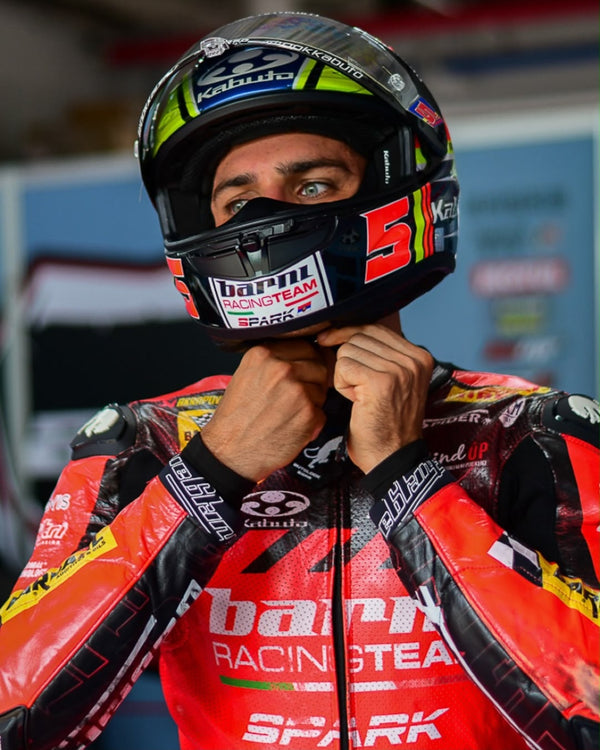 Rider fastening his No. 5 Kabuto helmet in Barni Racing Team leathers