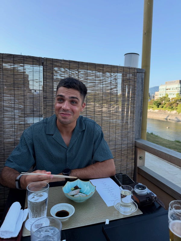 Man eating at a restaurant table by a river
